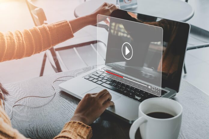 Woman watching online explainer video on laptop computer