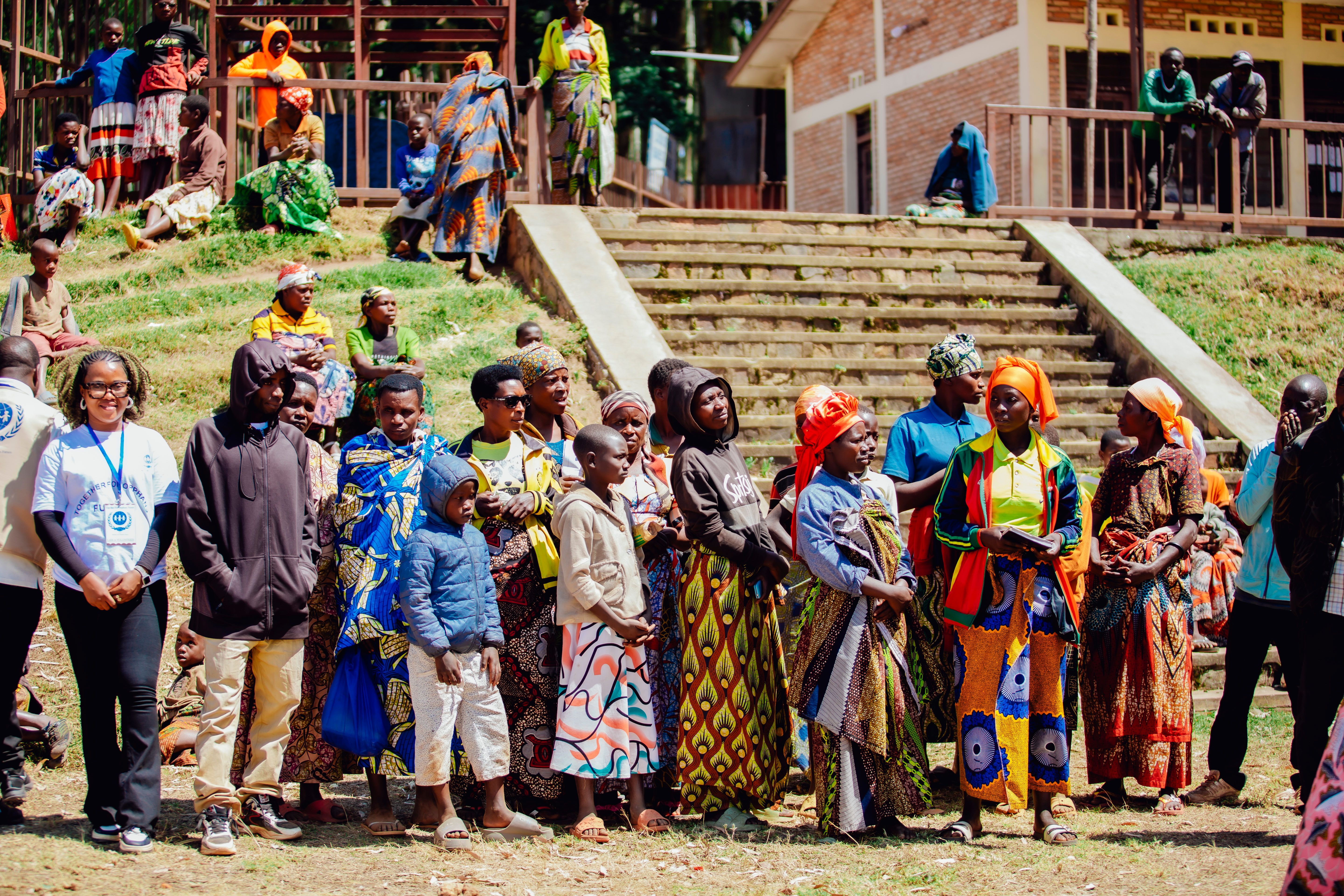 Group of people in vibrant traditional attire gathered outdoors, representing a diverse society