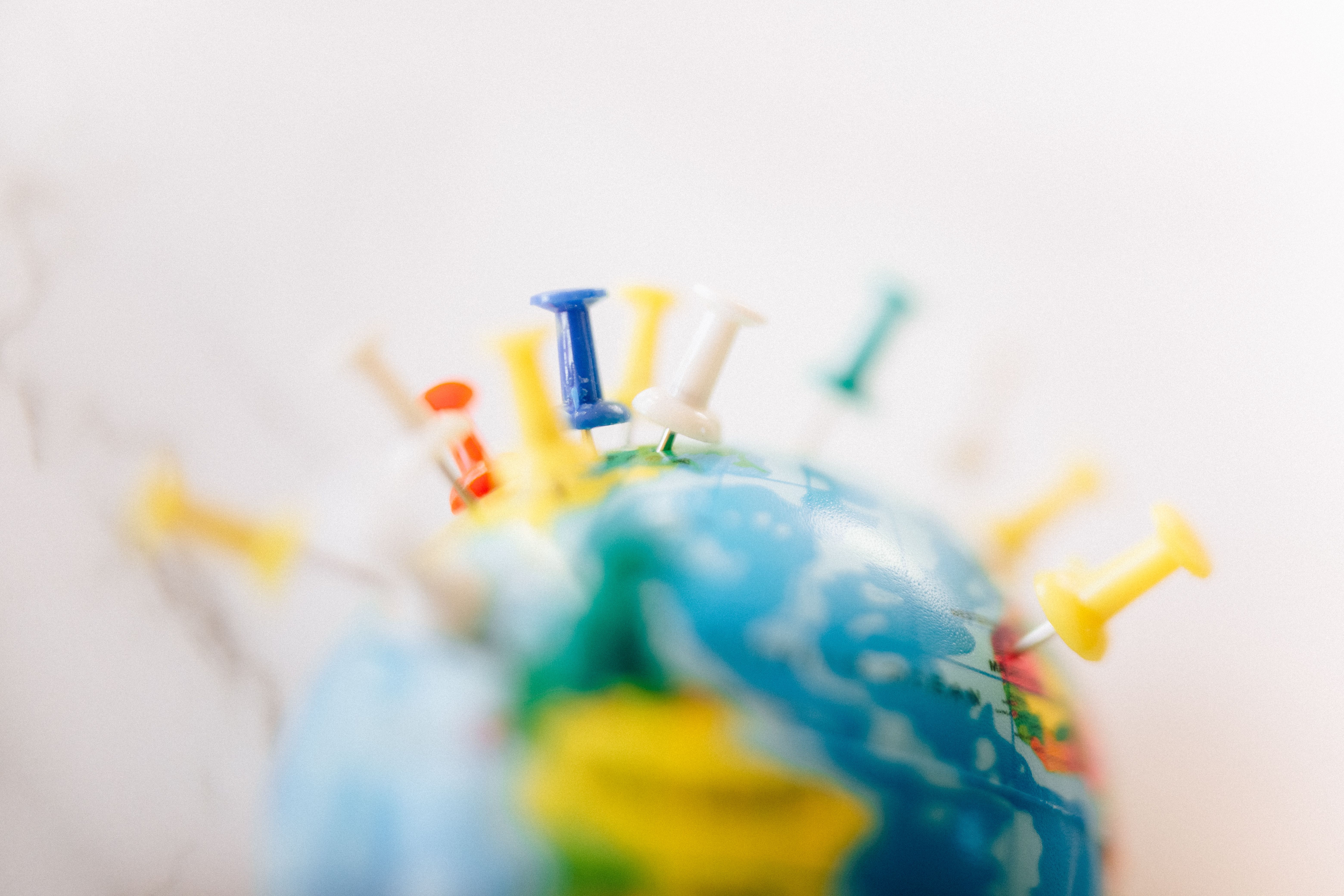 Globe marked with colorful push pins representing global government support systems