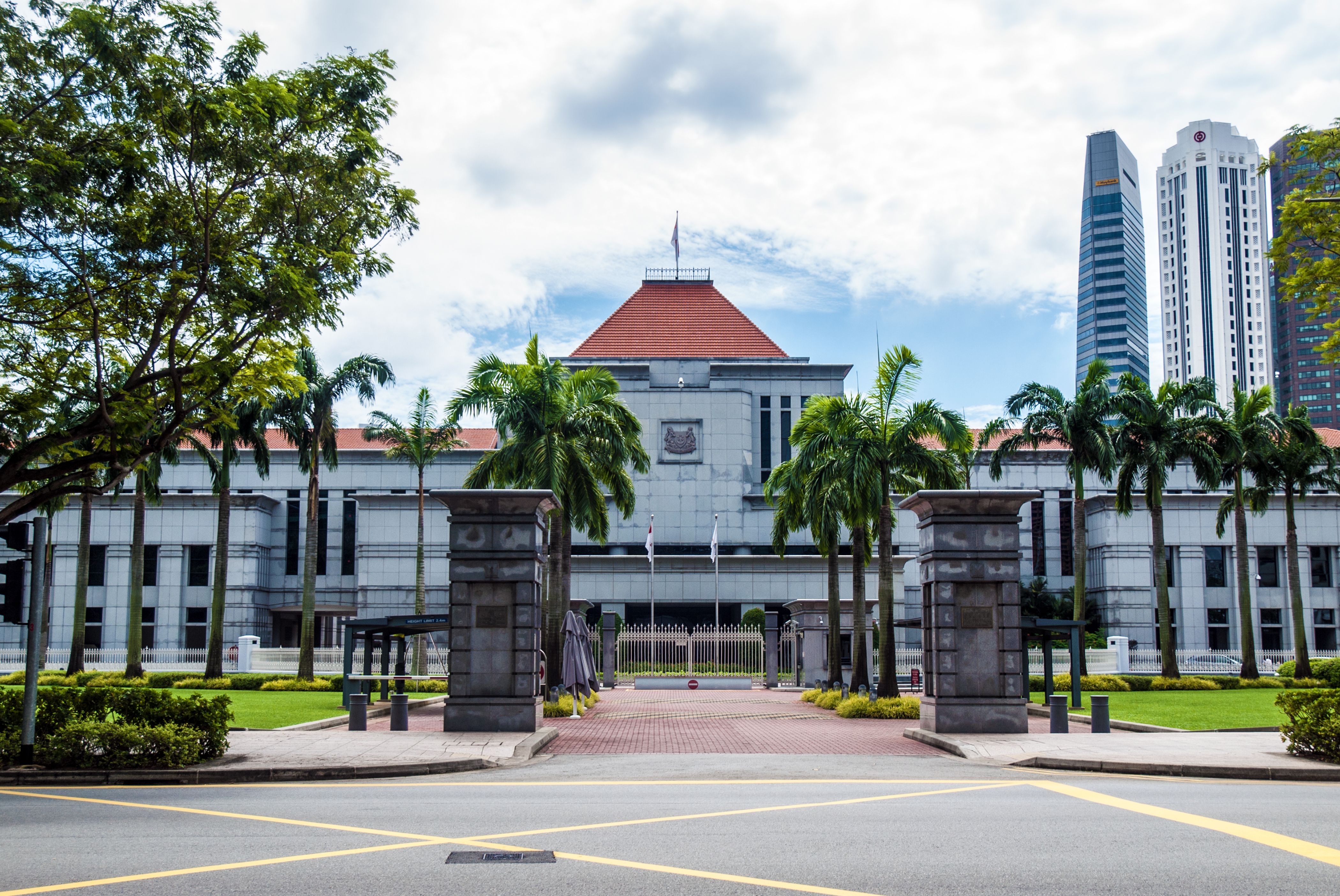 Exterior of the Singapore Parliament House with greenery and skyscrapers, representing government policy reform