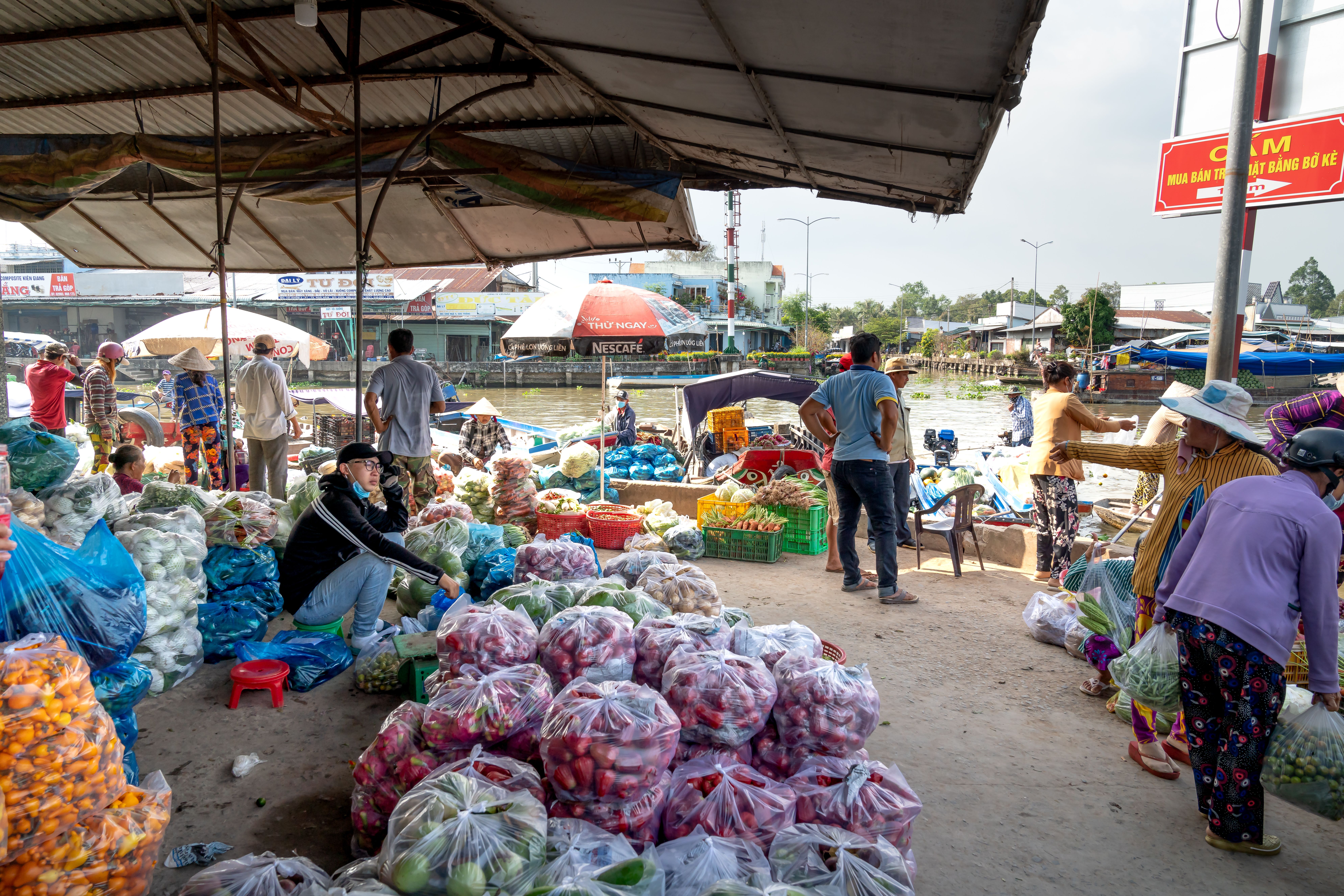 Vibrant outdoor market in Vietnam with fresh fruits and vegetables on display